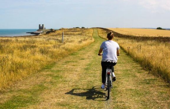 balance: kvinde cykler i naturen ved vandet