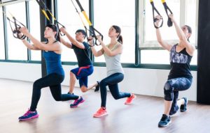 Folk laver TRX-lunges.