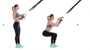 Kvinde laver TRX-squat.