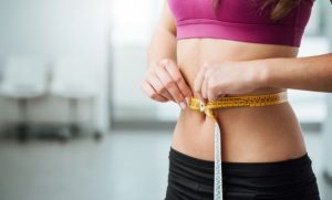 Kvinde måler sin talje.