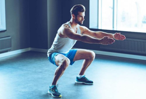 Mand der laver squats i et fitnesscenter