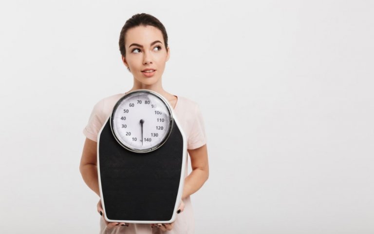 Pige der står med en vægt