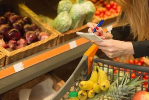 kvinde med indkøbsliste i supermarked