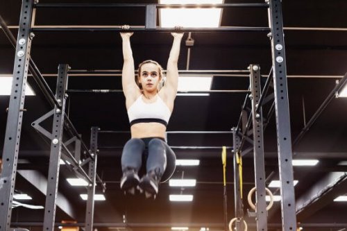 kvinde der træner i pull-up bar