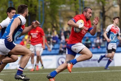 Rugbyspillere løber på banen