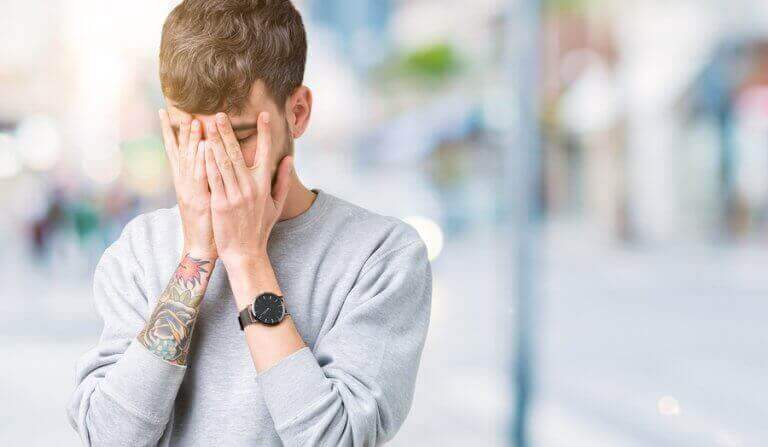 mand der holder sig for ansigtet