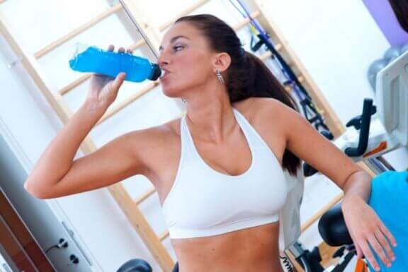 kvinde der drikker en isotonisk drik