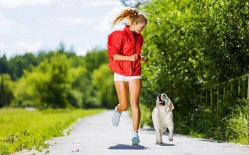 kvinde der løber på sti med en hund