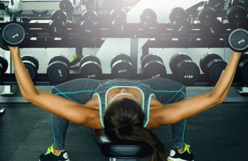 Kvinde træner med frie vægte