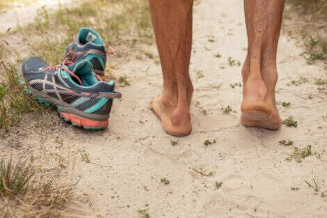 person der går barfodet i sand