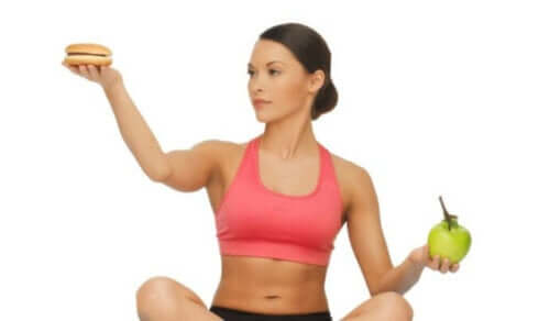 kvinde med burger og æble