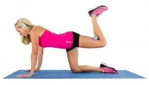 kvinde der laver øvelse med en håndvægt bag knæet