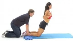 personlig træner der hjælper med øvelse