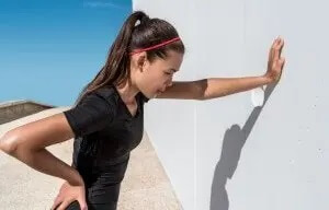 udmattet kvinde der støtter sig til væg